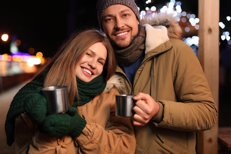 Happy couple with mulled wine at winter fairの写真素材