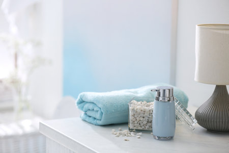 Soap dispenser, sea salt and towel on bathroom counterの写真素材