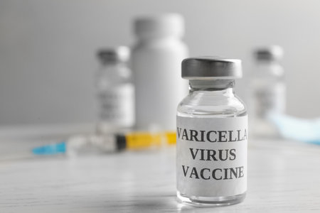 Chickenpox vaccine on white wooden table, space for text. Varicella virus preventionの写真素材