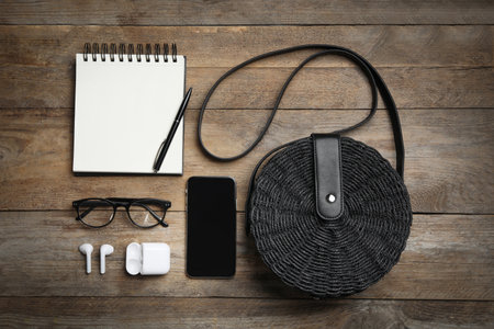 Flat lay composition with stylish woman's bag, smartphone and accessories on wooden backgroundの写真素材