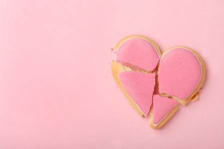 Broken heart shaped cookie on pink background, top view with space for text. Relationship problems conceptの写真素材