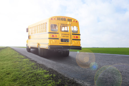 Yellow school bus on road outdoors. Transport for studentsの写真素材