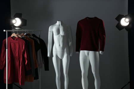 Ghost mannequins, clothes and professional lighting equipment in modern photo studioの写真素材