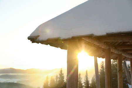 Wooden gazebo near snowy coniferous forest, closeup. winter holidaysの写真素材