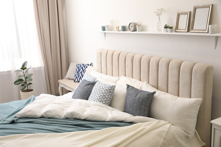 Comfortable bed with pillows in the room. Stylish interior designの写真素材