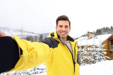 Happy man taking selfie at resort. winter holidaysの写真素材