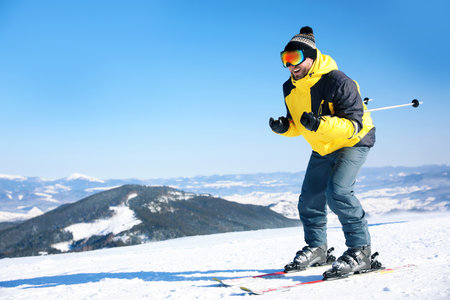 Young man skiing on hill, space for text. winter holidaysの写真素材