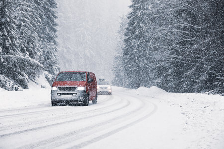 Snowy country road with modern cars on winter dayの写真素材