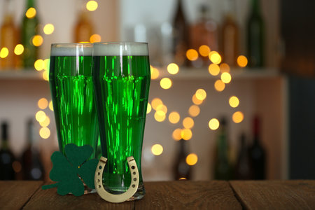 Green beer, horseshoe and clover on wooden counter, space for text. St.Patrick's Day celebrationの写真素材