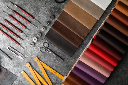 Flat lay composition with leather samples and craftsman tools on gray stone background