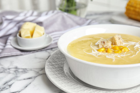 Delicious corn cream soup served on white marble table, closeup. Space for textの写真素材