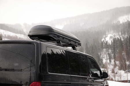 Black car with roof rack outdoors. winter holidays