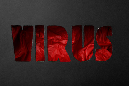 Word VIRUS cut out of black paper, top view