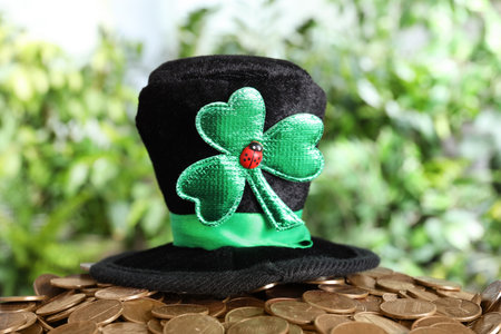 Black leprechaun hat with clover leaf on pile of gold coins. St Patrick's Day celebrationの写真素材