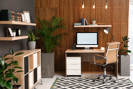 Comfortable workplace with computer near wooden wall in stylish room interior. home office designの写真素材