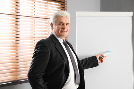 senior business trainer near flipchart in officeの写真素材