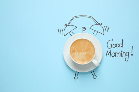 Composition with Good Morning wish and aromatic coffee on light blue background, top view. Space for...