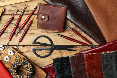 Flat lay composition with leather samples and tools on wooden table