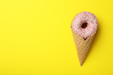 Ice cream made with donut on yellow background, top view. Space for textの写真素材