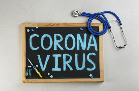 Chalkboard with words CORONA VIRUS and stethoscope on light background, flat layの写真素材