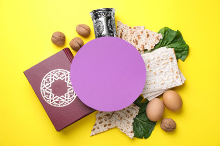 Frame made with symbolic Passover items and blank card on yellow background, space for text. Pesah...
