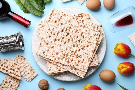Flat lay composition with symbolic Pesach (Passover Seder) items on light blue background