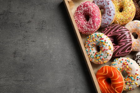 Top view of yummy donuts with sprinkles in box, space for textの写真素材