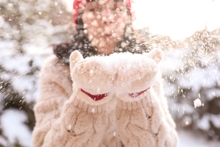 Young woman blowing snow outdoors, closeup. winter holidaysの写真素材