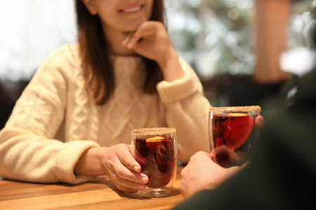 Couple with mulled wine at table in cafe, closeup. winter holidays