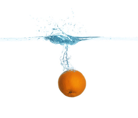 Ripe orange falling down into clear water with splashes against white backgroundの写真素材