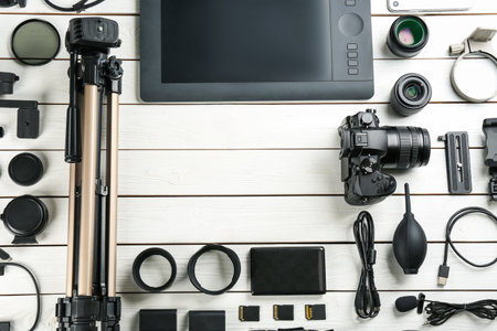 Flat lay composition with camera and video production equipment on white wooden table. Space for textの写真素材