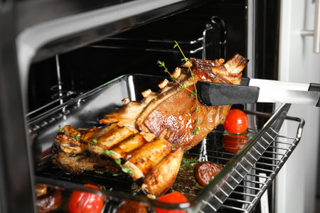 Delicious roasted ribs in oven, closeup. Yummy meat