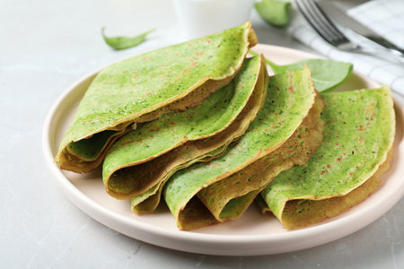 Tasty spinach crepes on light gray table, closeupの写真素材