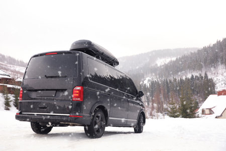 Black car on snowy road. winter holidays