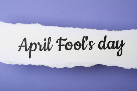 Paper note with phrase APRIL FOOL'S DAY on lilac background, top viewの写真素材
