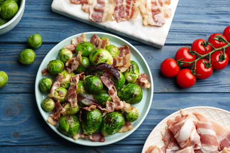 Delicious Brussels sprouts with bacon on blue wooden table, flat layの写真素材