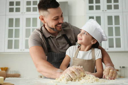 Father and daughter cooking together in the kitchenの写真素材