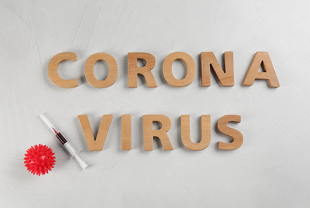 Words CORONA VIRUS and syringe on light background, flat layの写真素材