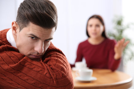 Unhappy man after quarrel with his girlfriend indoors. relationship problemsの写真素材