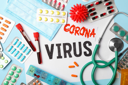 Flat lay composition with phrase CORONA VIRUS and medicines on light blue backgroundの写真素材
