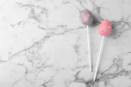 Egg shaped cake pops and space for text on white marble table, flat lay. easter celebrationの写真素材