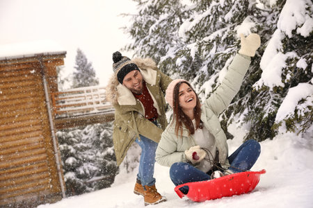 Couple having fun and sledding on snow. winter holidaysの写真素材