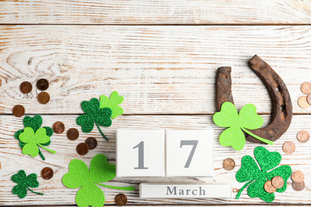 Flat lay composition with horseshoe and block calendar on white wooden background, space for text....