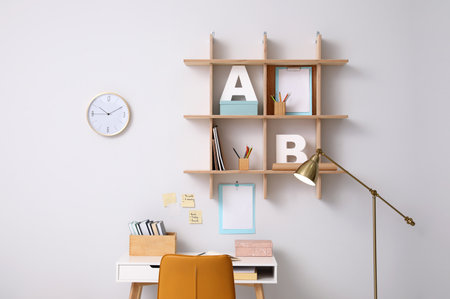 Comfortable workplace with wooden furniture and floor lampの写真素材
