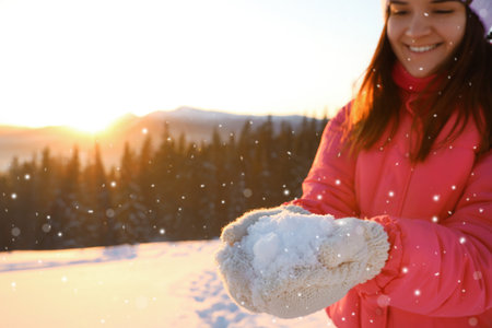 Woman holding a pile of snow outdoors. winter holidaysの写真素材