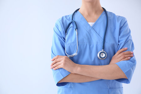 Young doctor with stethoscope on light background, closeupの写真素材