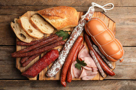 Different tasty sausages on wooden table, top viewの写真素材
