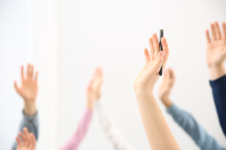 People raising hands to ask questions at business training on white background, closeupの写真素材