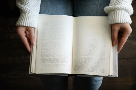 Young woman reading book indoors, top viewの写真素材
