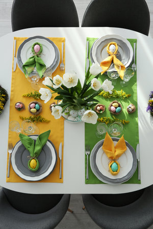 Festive Easter table setting with beautiful tulips and eggs, top view